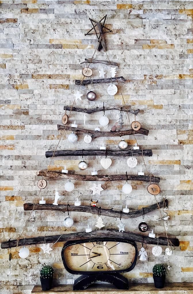 A unique DIY Christmas tree on a rustic brick wall, featuring natural materials and simple decorations.