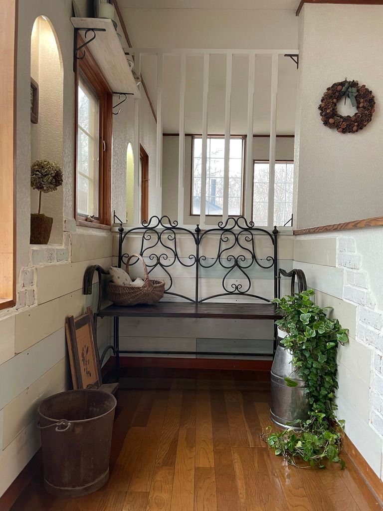 Inviting indoor corner featuring a wrought iron bench and rustic decor elements.
