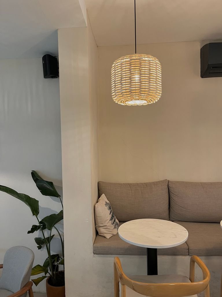 Peaceful cafe setting featuring modern decor with a sofa, round table, and pendant light.